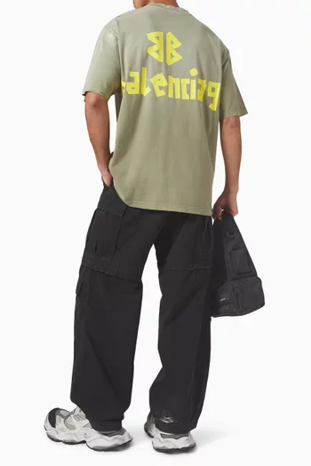 تي شيرت فضفاض قليلاً بشعار الماركة بتصميم أشرطة جيرسيه باهت